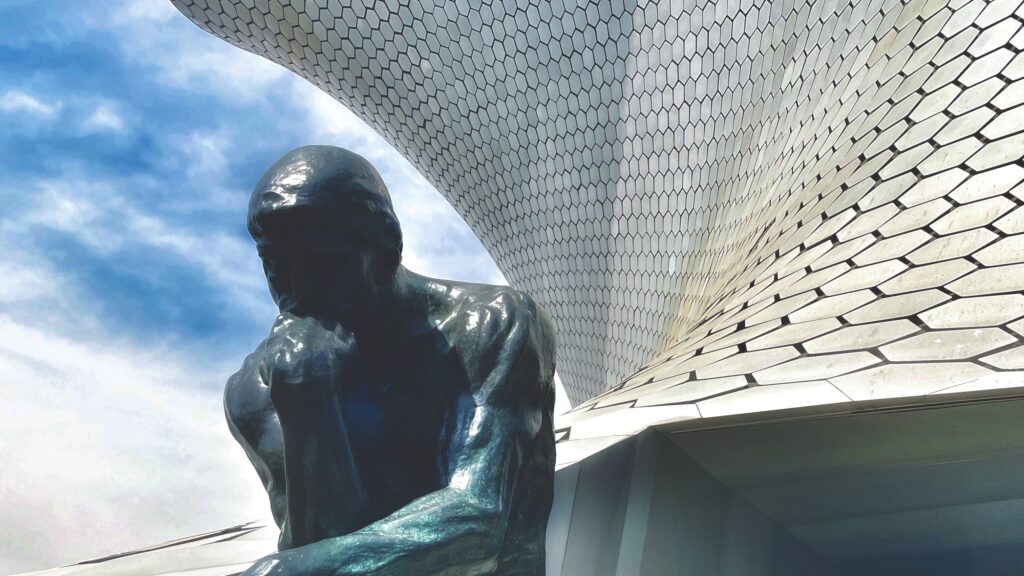 De denker van Rodin zit voor het zilveren museum Soumaya in Mexicostad