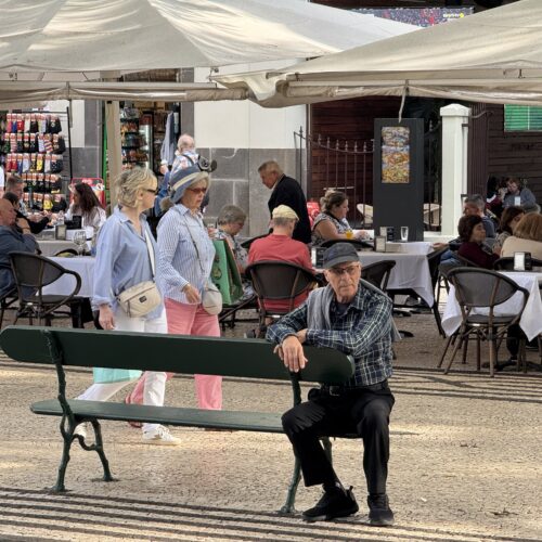 Struinen op de boulevard of gewoon even zitten op een bank zoals deze Portugese man op Madeira.